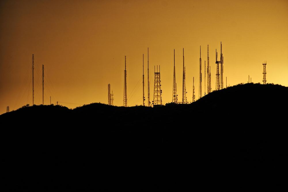 Communication towers silhouetted at sunset